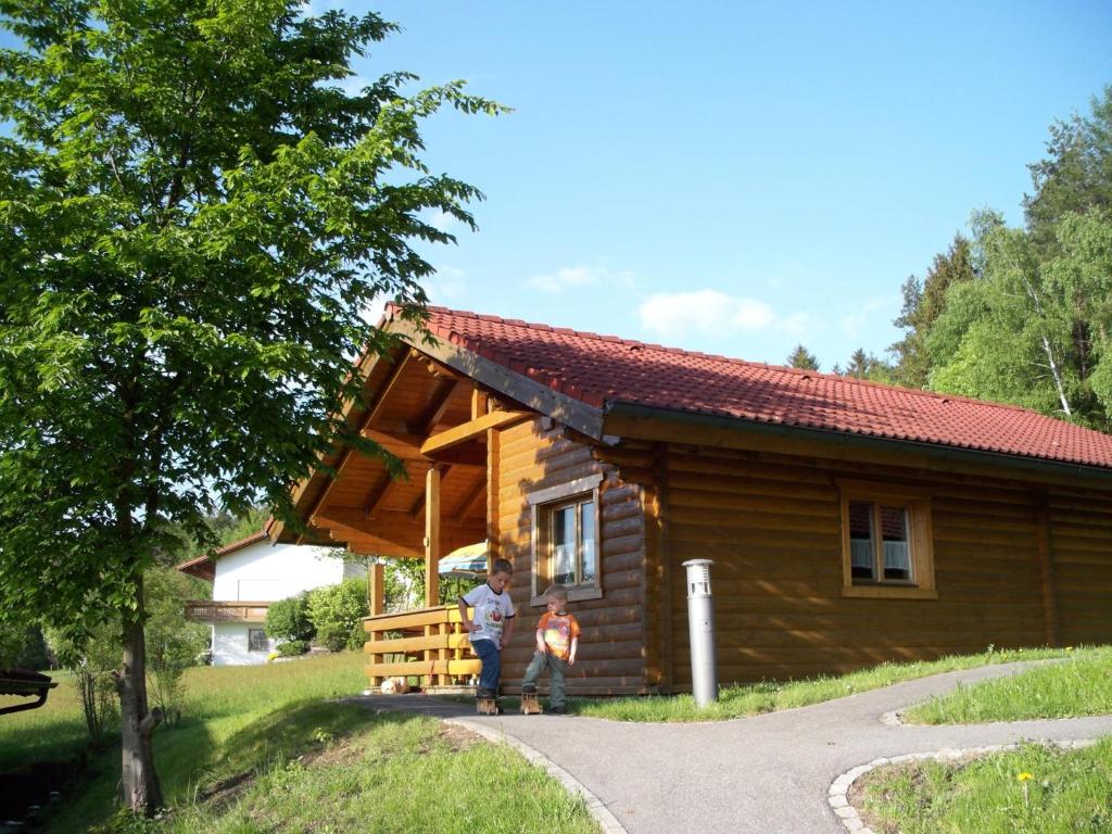 two people standing outside of a log cabin at Blockhaus Hedwig in Stamsried