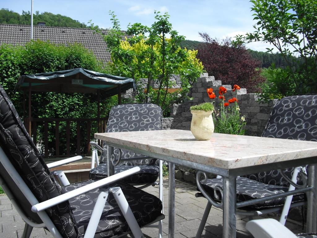 una mesa y sillas con un jarrón en el patio en Haus Schnurbus, en Olsberg