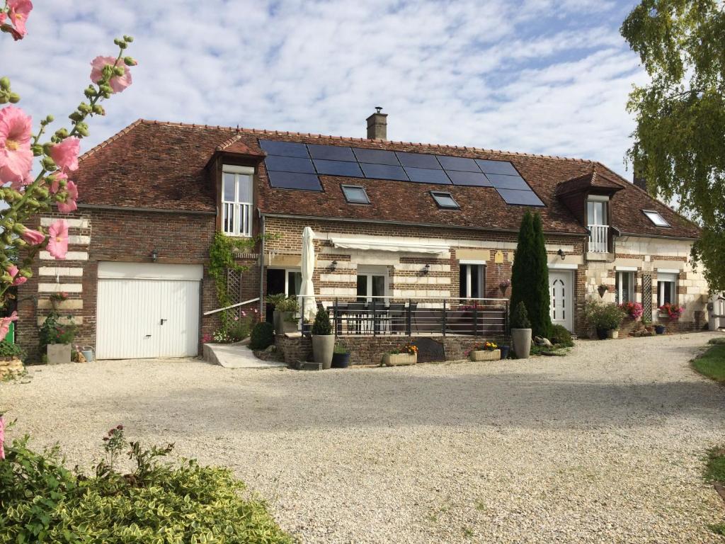 una casa con paneles solares en el techo en La longère Champenoise en Prugny