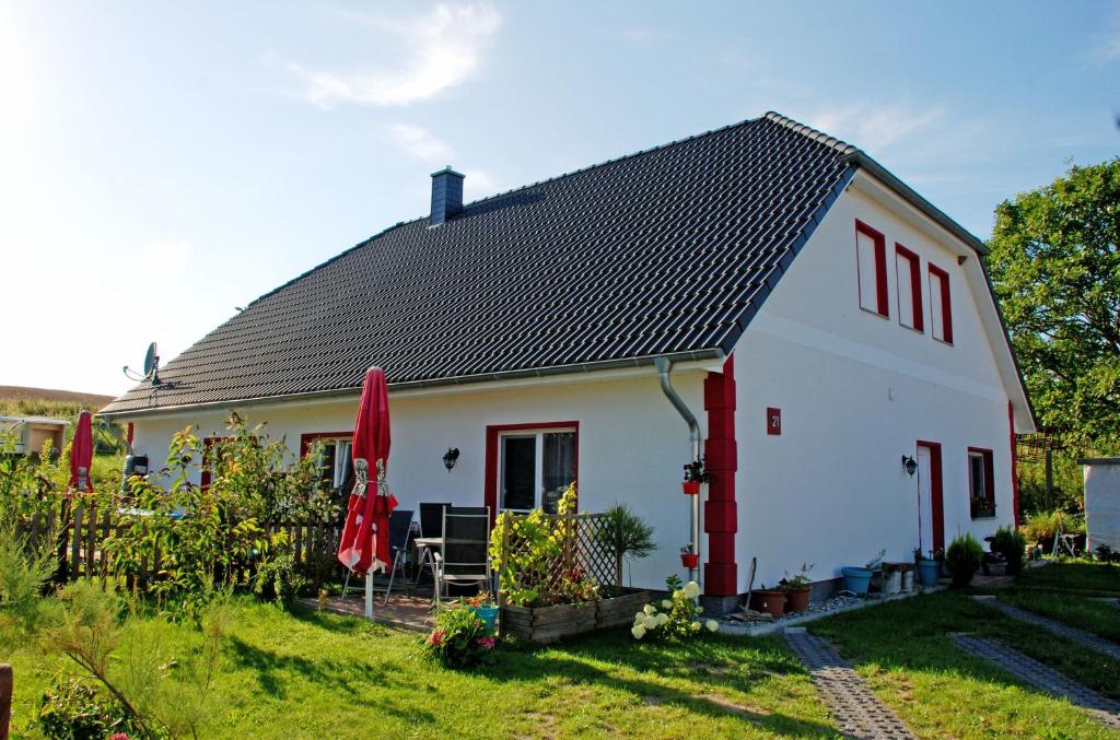 a white house with a black roof at Ferienwohnung "Am Feld" in Lancken-Granitz