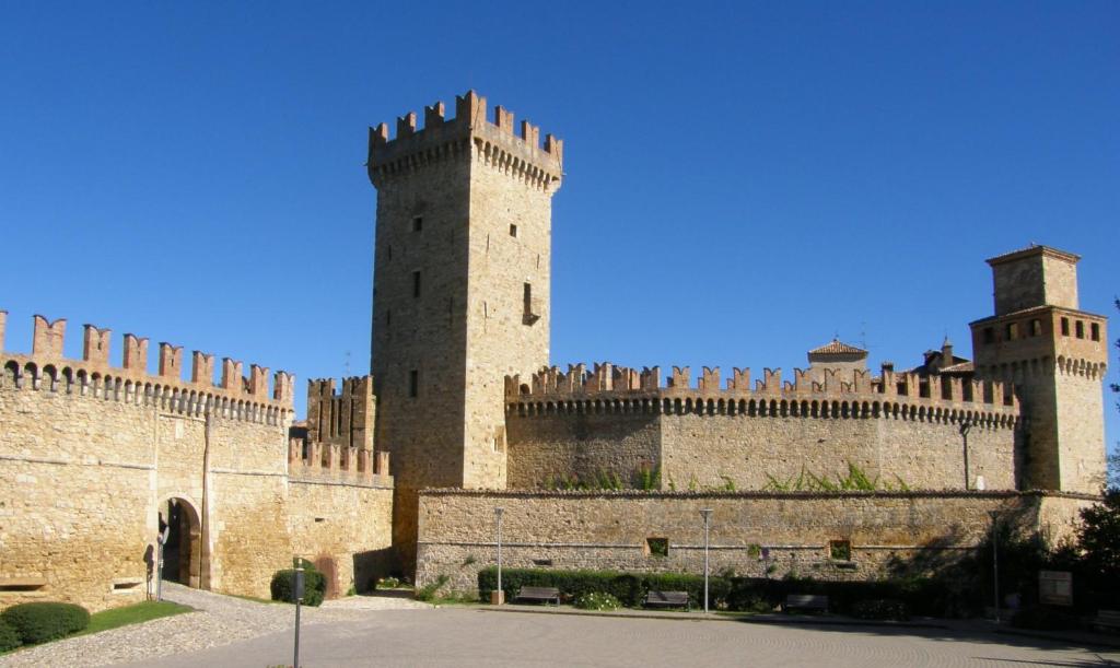 un château avec deux tours et un mur dans l'établissement Hotel Castello Di Vigoleno, à Vigoleno
