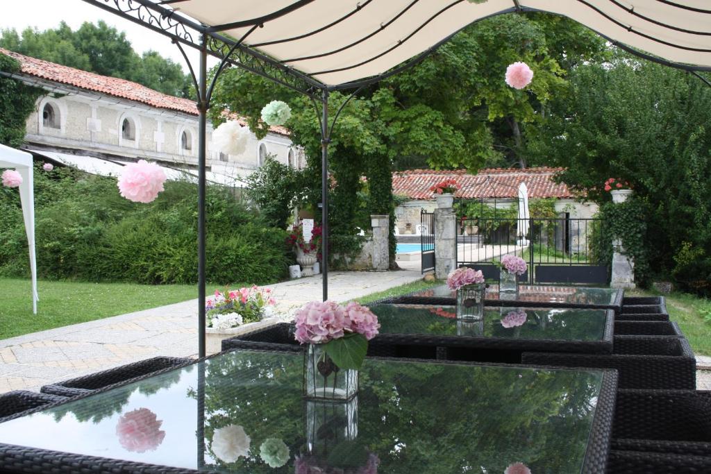 un jardín con una mesa con flores. en Chateau de Fayolle, en Ribérac