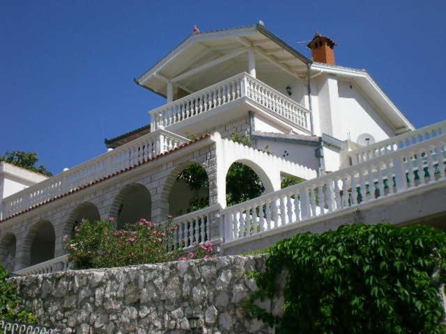 une maison blanche avec une balustrade blanche et une clôture dans l'établissement Villa I Karma, à Tisno