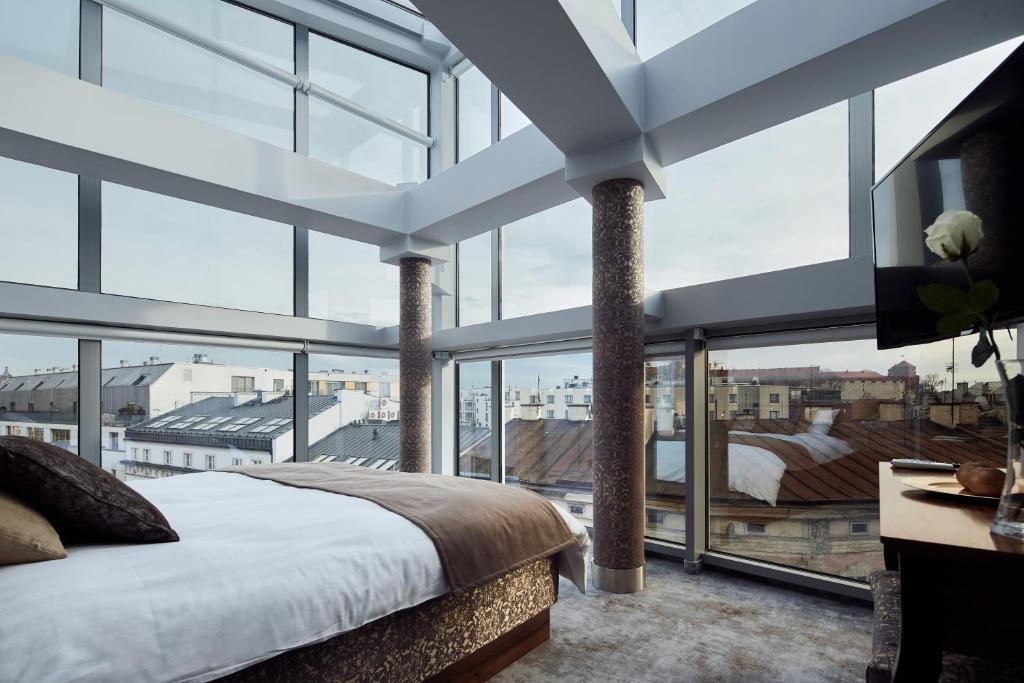 - une chambre avec un lit et de grandes fenêtres dans l'établissement Aparthotel Best Views, à Cracovie