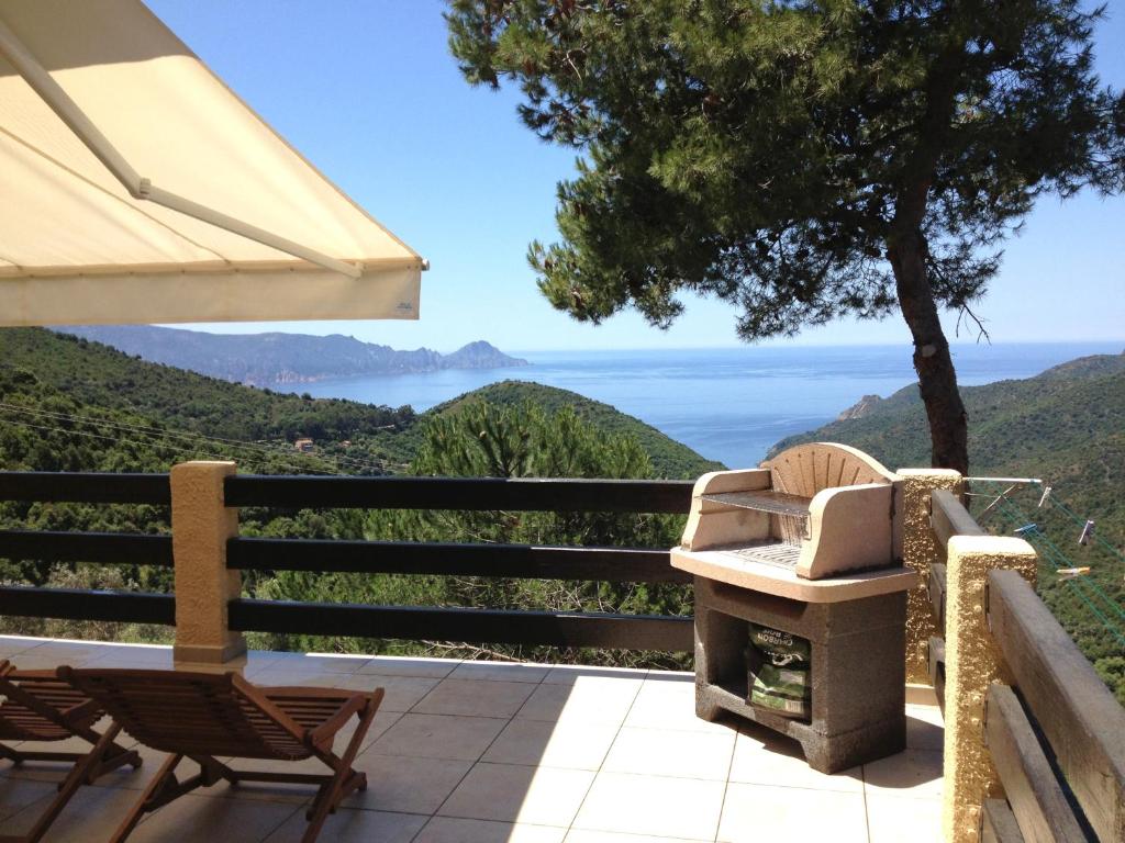 eine Terrasse mit einem Stuhl und einem Sonnenschirm in der Unterkunft Villa Romarin in Partinello