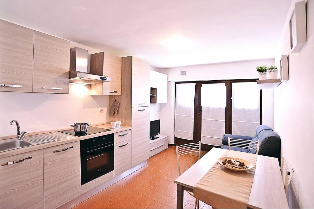 a kitchen with white cabinets and a table and a dining room at Il Rifugio del Paguro in Porto Recanati