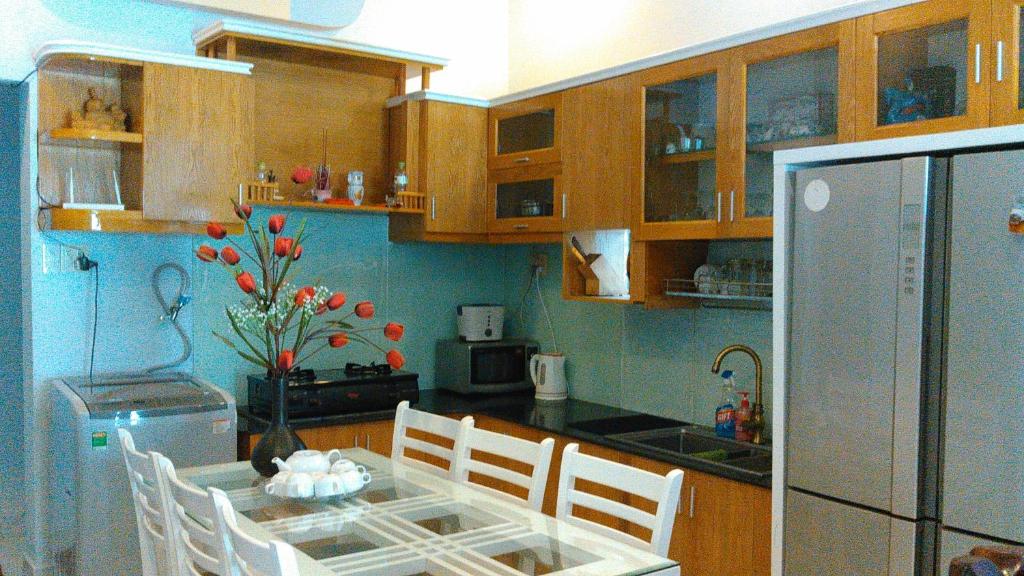 Una cocina con una mesa con sillas y un refrigerador. en VKS Family Surfer House, en Phan Thiet