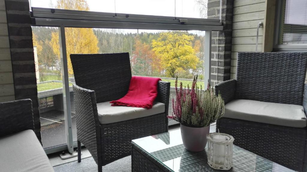 ユヴァスキュラにあるFeels Like Home Laajalahtiのバルコニー(椅子2脚、テーブル付)、窓が備わります。