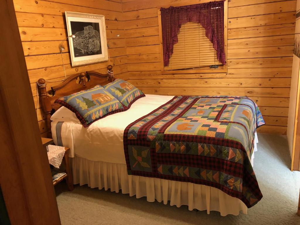 um quarto com uma cama num chalé de madeira em The Gingerbread Cabin em Jasper