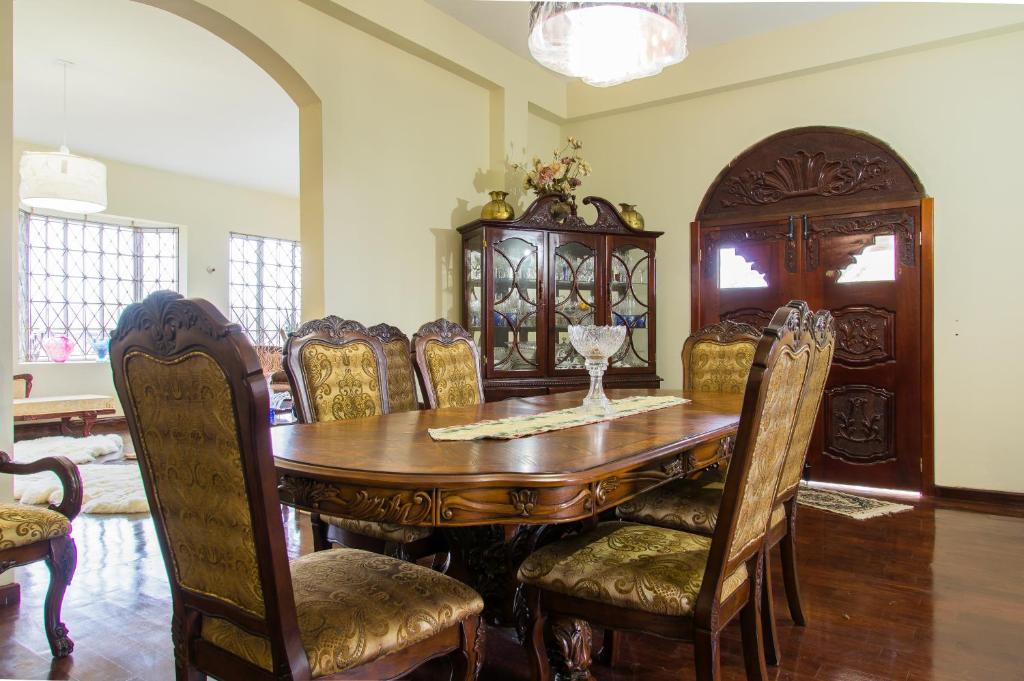 a dining room with a wooden table and chairs at El Cielo in Portmore