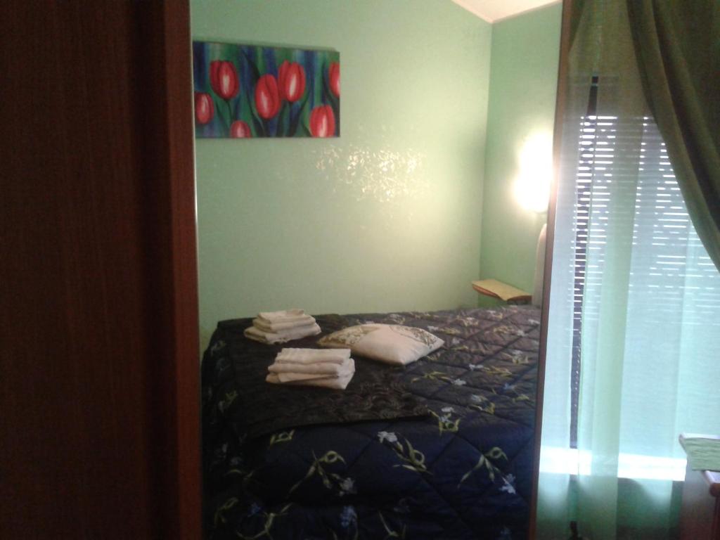 a bedroom with a bed and a painting of red tulips at Bed&breakfast Sole&luna in Messina