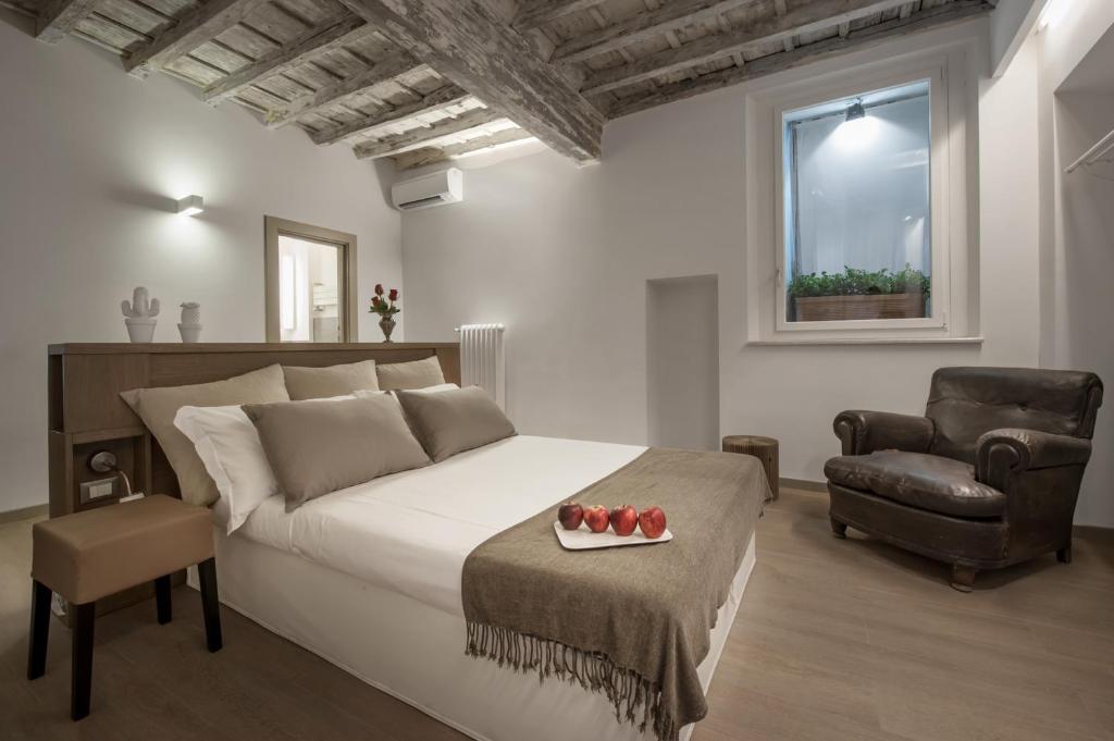 um quarto com uma cama grande e uma cadeira em Raffaello Charmsuite em Roma