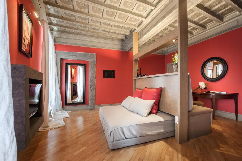 a bedroom with red walls and a bed in a room at Raffaello Charmsuite in Rome