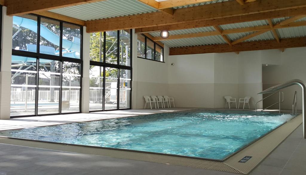 - une grande piscine intérieure dans un bâtiment doté de fenêtres dans l'établissement Camping Eden, à La Baule