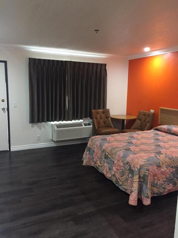 a hotel room with a bed and a table and chairs at Welcome Inn & Suites Anaheim in Anaheim