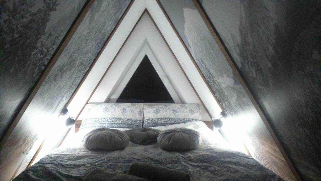 a bedroom with a bed with a triangular headboard at Apartament Palisander in Kościelisko