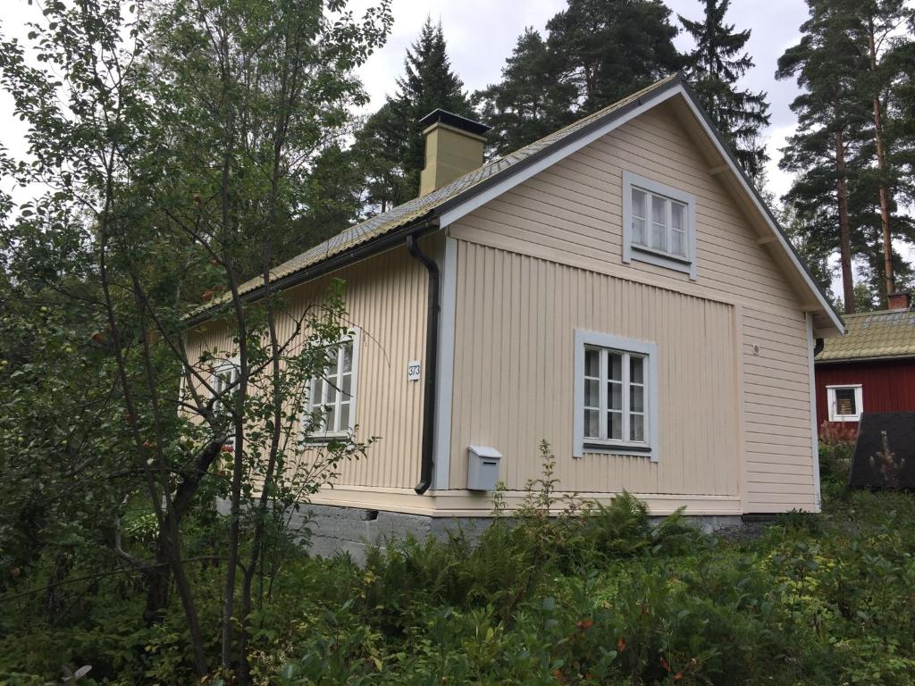 a small house in the middle of a yard at Metsäranta House in Tammela