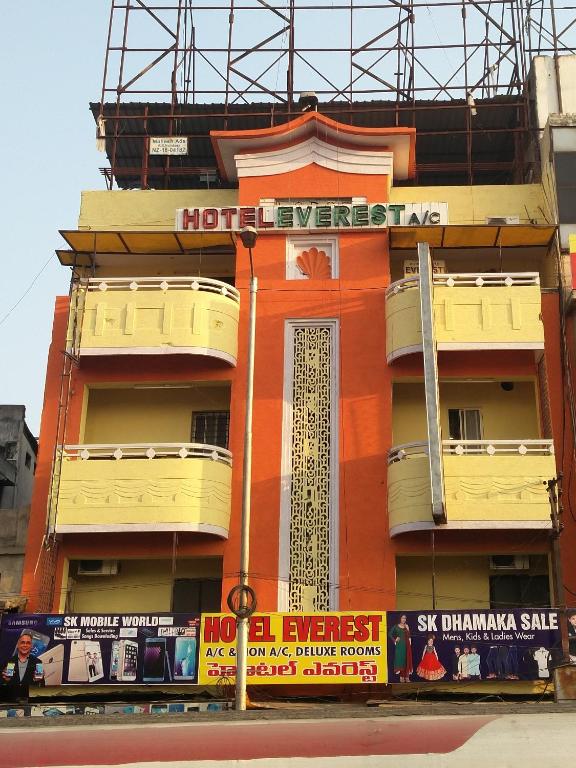 a tall orange building with signs on it at Hotel Everest in Hyderabad