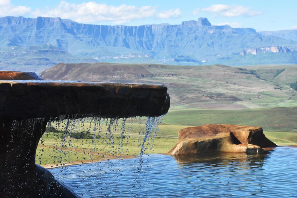 una piscina d'acqua con montagne sullo sfondo di Berghouse and Cottages a Langkloof