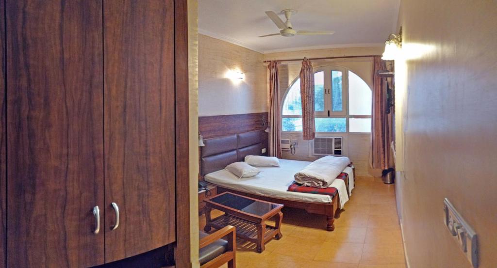 a small bedroom with a bed and a window at Hotel Rangoli in Jaipur