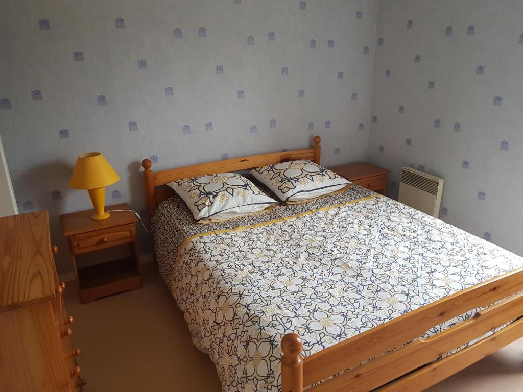 1 dormitorio con 1 cama y 1 lámpara en una mesa en L'Oustalou en Viéville