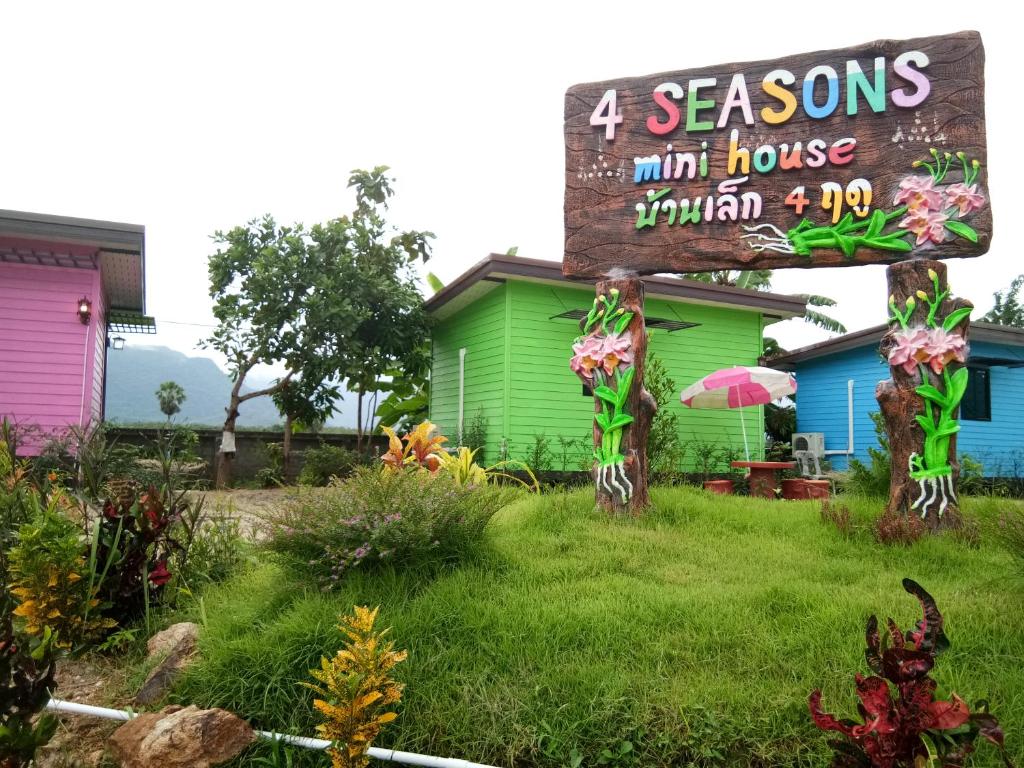 a sign in front of a colorful house at 4 seasons mini house in Nakhon Si Thammarat