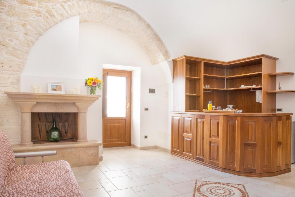 a living room with a fireplace and wooden cabinets at Masseria Cappella in Martina Franca