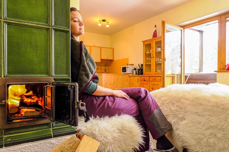 a woman sitting in front of a fireplace at Apartment Lakeside in Turracher Hohe