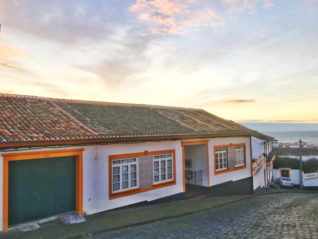 a small white house with a view of the ocean at Casa do Pisão - Cosy and Modern Two-Bedroom Townhouse in Angra do Heroísmo
