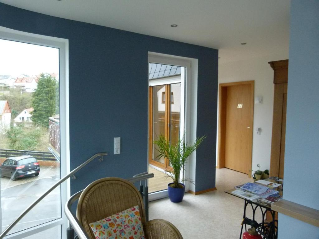 a living room with a blue accent wall at Hotel Holzhauer in Bad Wildungen