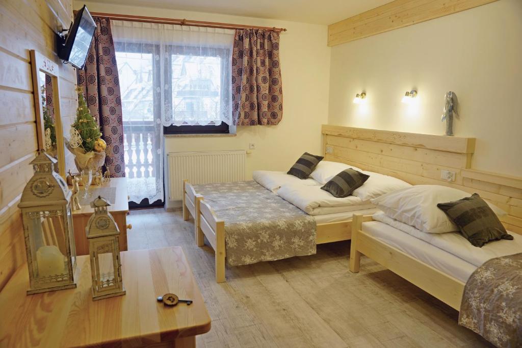 Sala de estar con 2 camas y mesa en Willa 14, en Zakopane