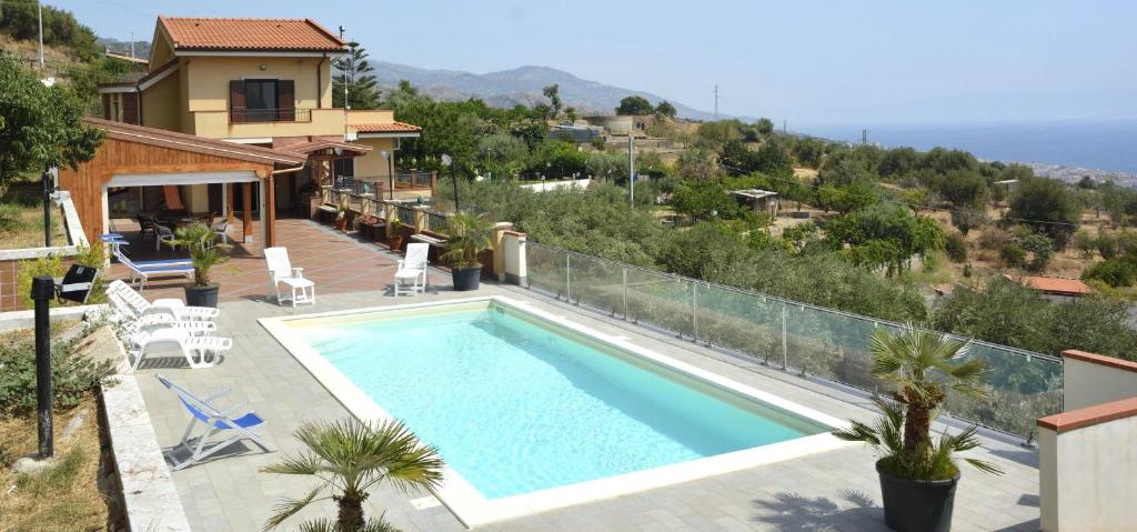 una piscina in una villa con una casa di Villa Gemma di Mare a Santa Teresa di Riva