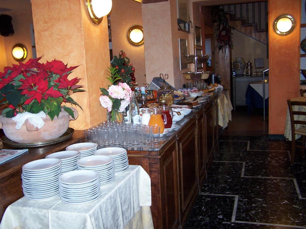 a kitchen with a buffet with white plates and flowers at Hotel Bucaneve in Bardonecchia