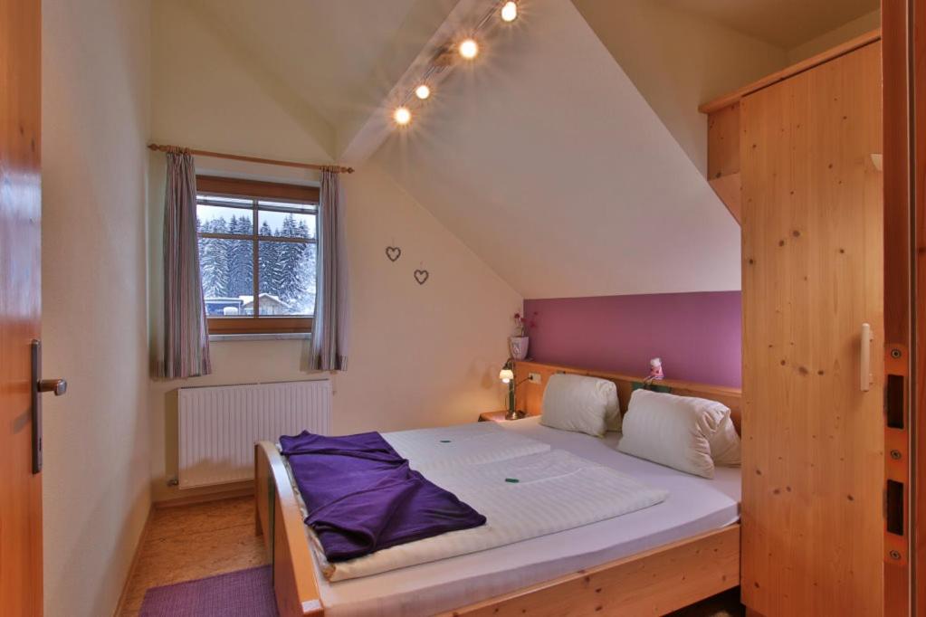 1 dormitorio con 1 cama grande en el ático en Gästehaus Berger, en Tröpolach