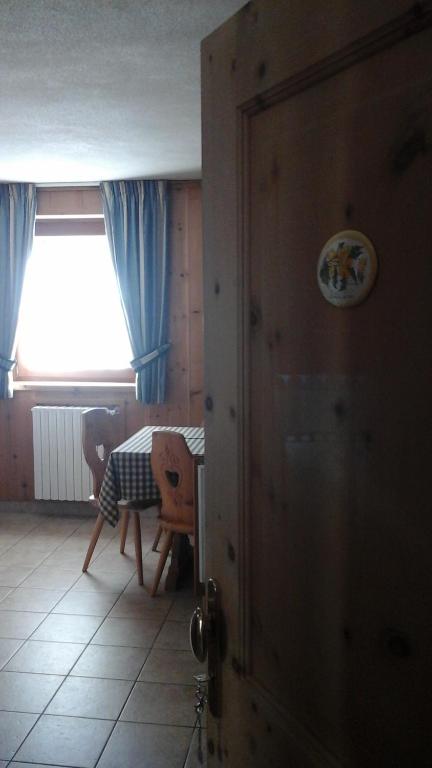 Zimmer mit einem Tisch, einem Stuhl und einem Fenster in der Unterkunft Chalet Le Betulle in Santa Caterina Valfurva