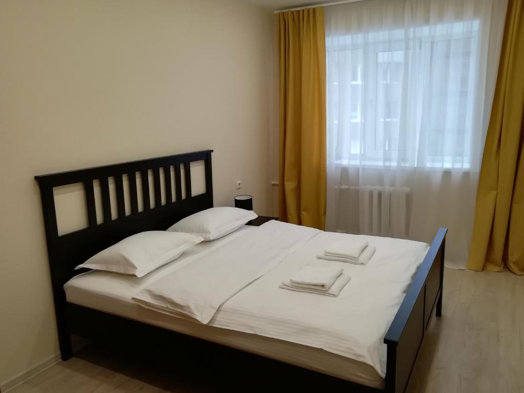ノヴォシビルスクにあるApartments Domant Ploshchad Leninaのベッドルーム1室(大型ベッド1台、白いシーツ、枕付)