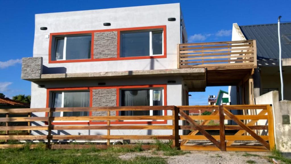 una casa con una valla de madera delante de ella en Apartamentos Croacia del Mar en Santa Clara del Mar
