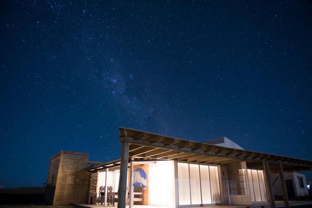 una vista nocturna de un edificio con estrellas en el cielo en El fortín del Rubio, en Cabo Polonio