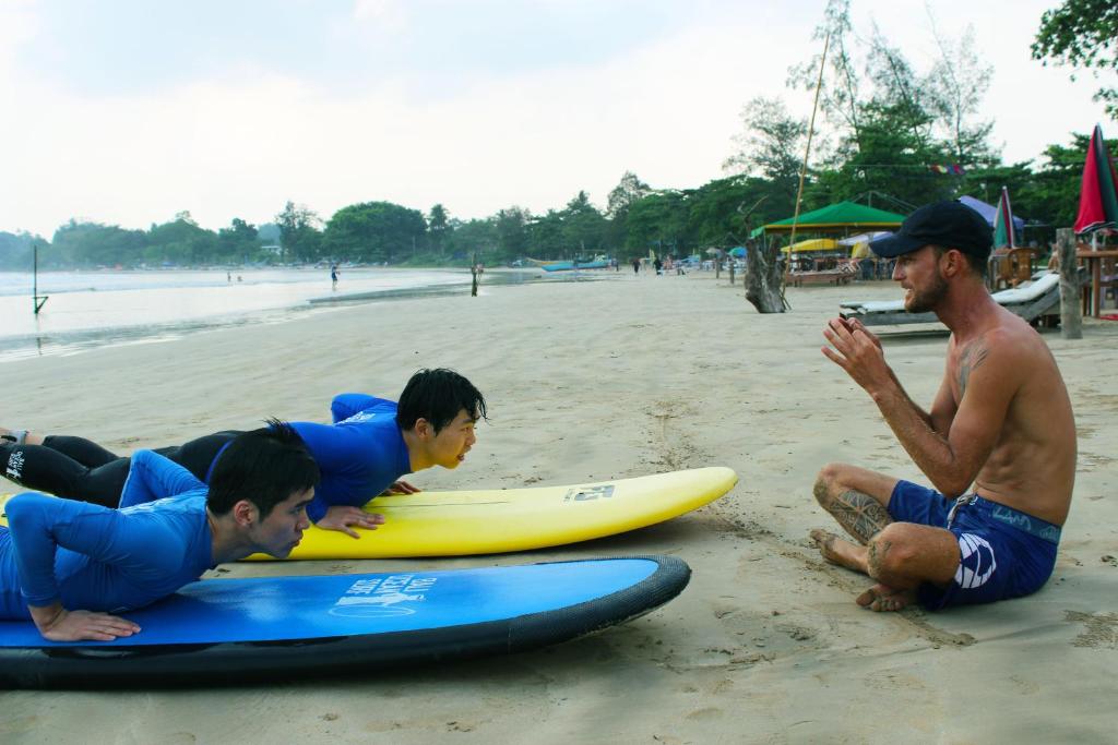 a group of people laying on surfboards on the beach at Surasa Beach Resort in Weligama
