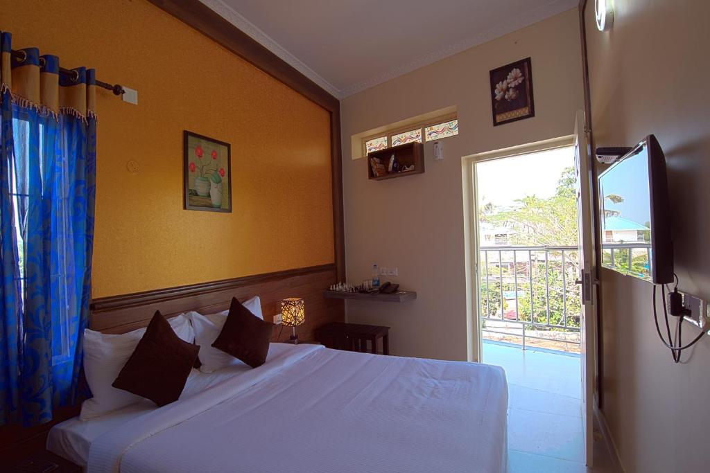 a bedroom with a white bed and a window at Gems 9 Airport Hotel in Nedumbassery