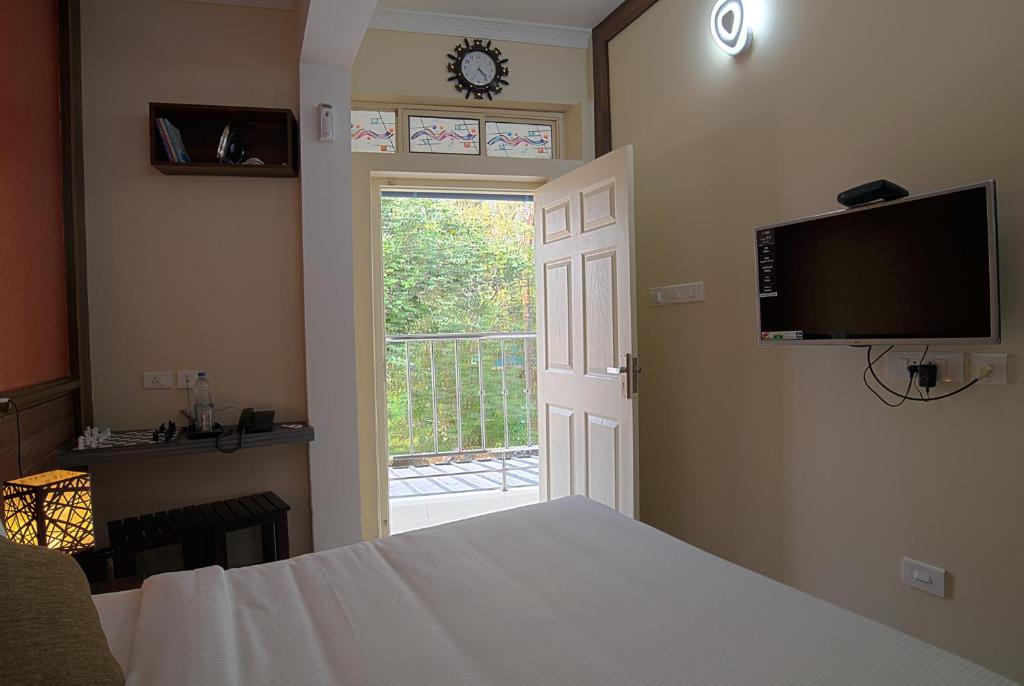 a bedroom with a bed and a tv and a window at Gems 9 Airport Hotel in Nedumbassery