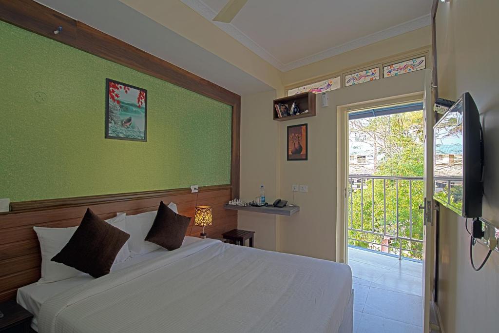 a bedroom with a white bed and a window at Gems 9 Airport Hotel in Nedumbassery