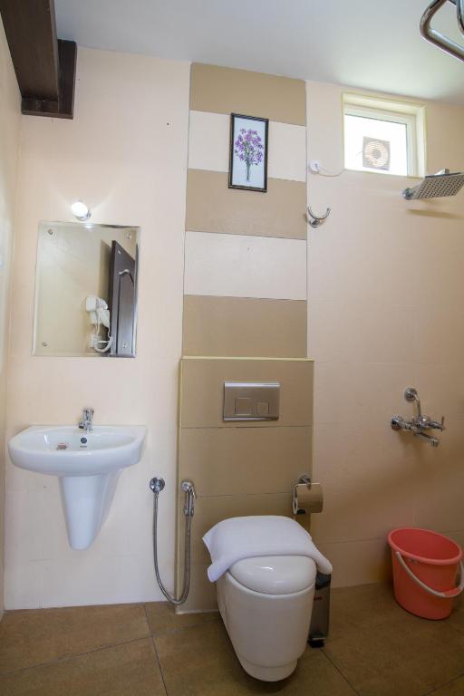 a bathroom with a toilet and a sink at Gems 9 Airport Hotel in Nedumbassery