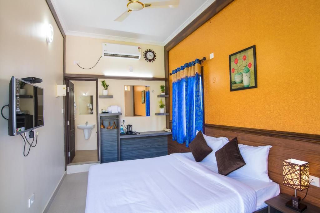 a bedroom with a white bed and a bathroom at Gems 9 Airport Hotel in Nedumbassery