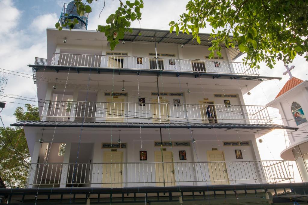 a large white building with balconies on it at Gems 9 Airport Hotel in Nedumbassery