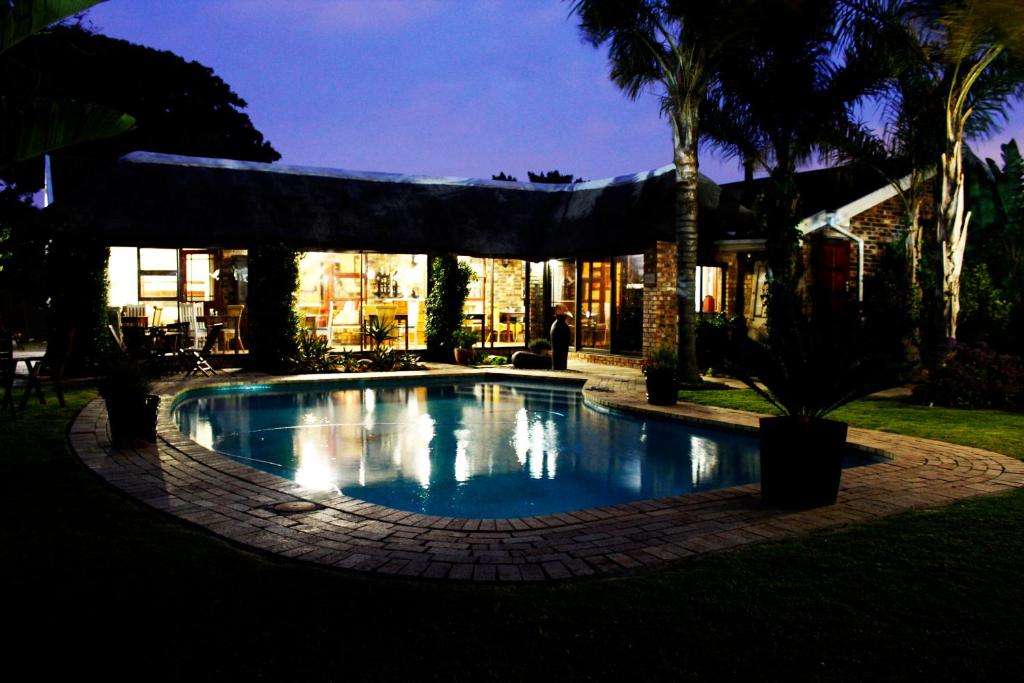 a swimming pool in front of a building at Amani Guest Lodge in Port Elizabeth