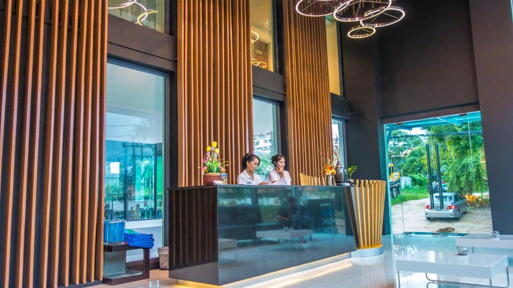 Dos mujeres están de pie en un mostrador en un edificio en Unique Regency Pattaya, en Pattaya South