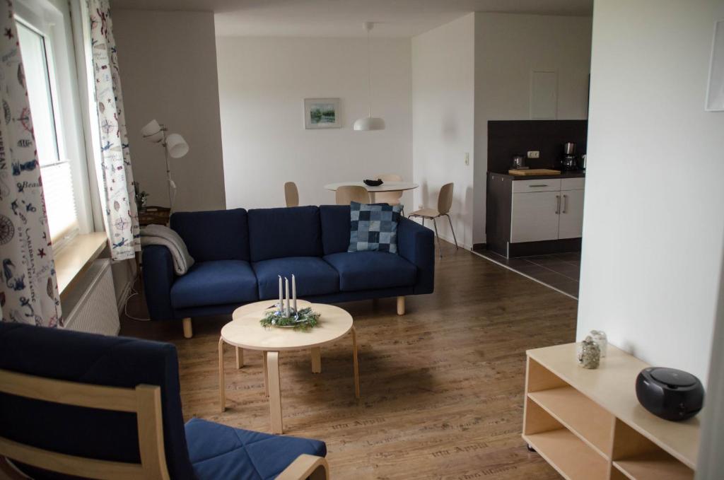 a living room with a blue couch and a table at Ferienwohnung 2 Kormoran in Sagard