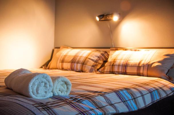1 dormitorio con 1 cama con toallas en Apartment Bohemian Rhapsody, en Belgrado