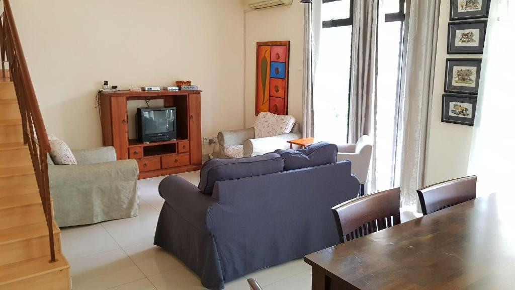 a living room with two couches and a tv at Alyssa Homestay Putrajaya in Putrajaya